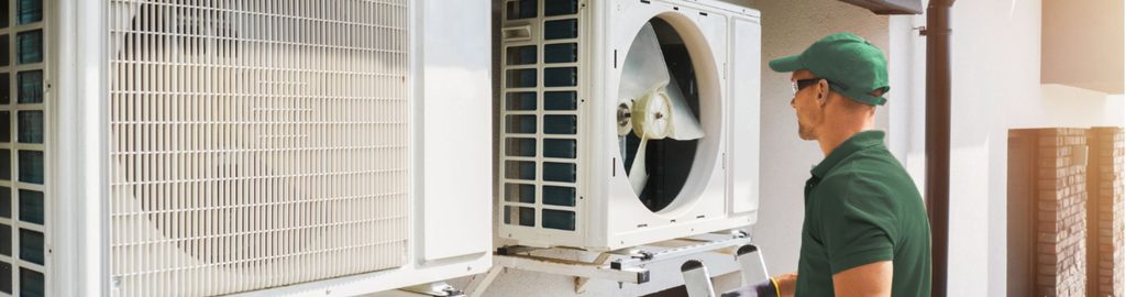 A technician standing beside a heat pump.