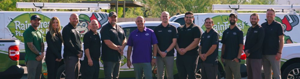 The smiling Rainforest crew in front of their branded vehicles