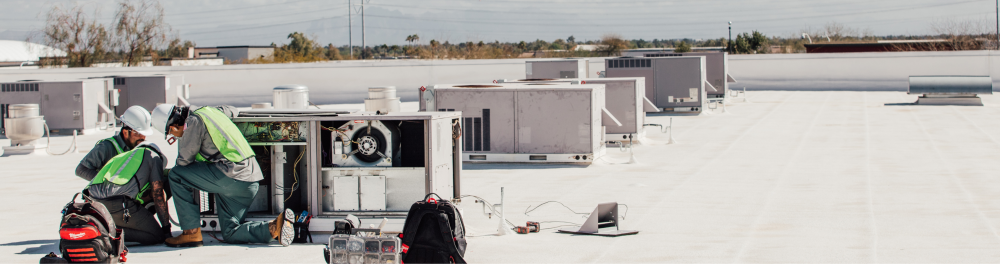 The Rainforest team carefully inspecting a roof top AC unit.